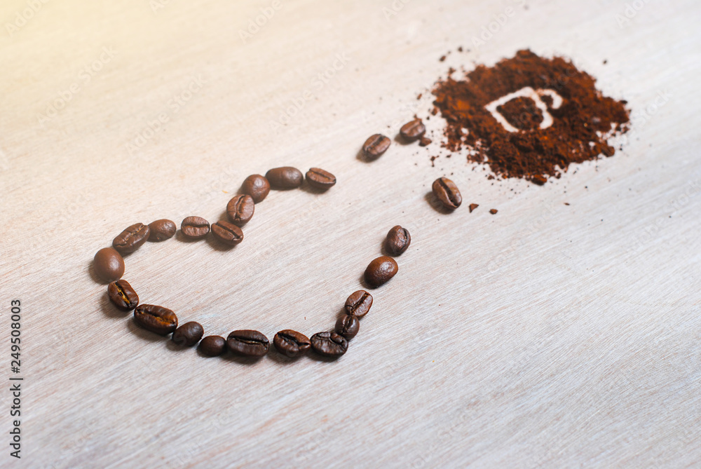 Coffee beans heart of coffee beans turning into a cup. Cup made of coffee beans with heart on the light canvas. Coffee beans heart of coffee beans turning into a cup. Cup made of coffee beans with heart on the light canvas.
