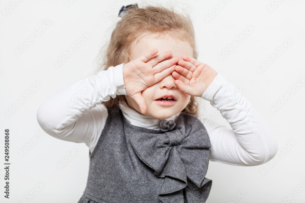 Cute little girl, evil emotion, close-up, light background Cute little girl, evil emotion, close-up, light background