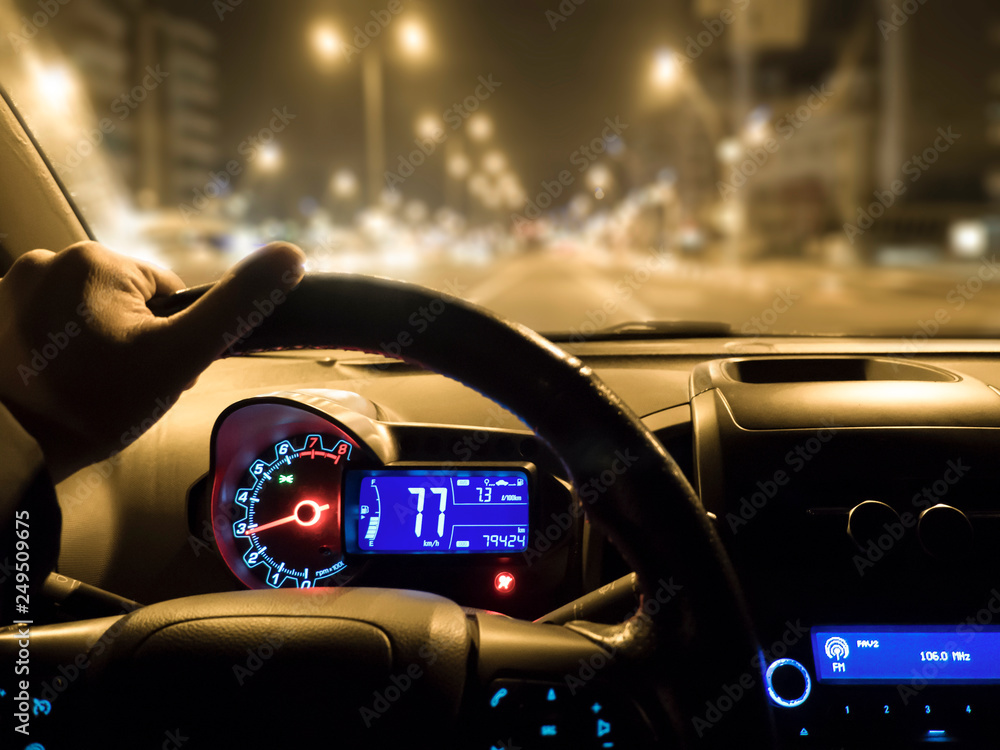 car use on night road. man holding steering wheel in car