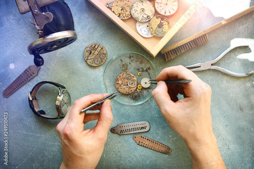 Watchmaker at work in workshop. Flat lay. Workplace of watch repairer. Process of repair mechanical watches.. photo