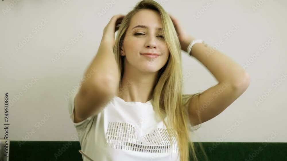 Happy young woman with blonde hair dancing sitting at the table in the cafe. 4K Happy young woman with blonde hair dancing sitting at the table in the cafe. 4K