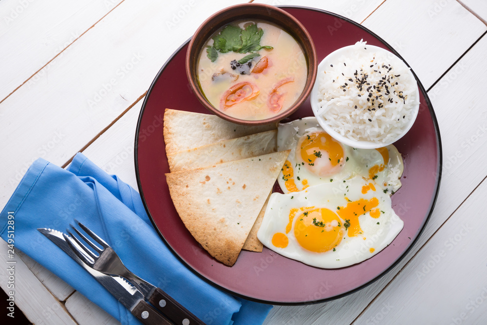 Asian breakfast of rice, soup and fried eggs