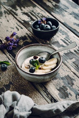 Greek Yogurt with Banana and Bluberries on a Wooden Background, selelctive focus photo