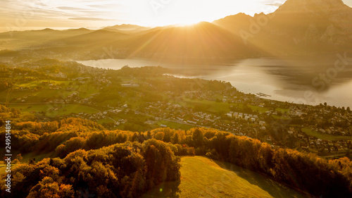 Fotografie great sunrise behind a huge mountain in Austria with a amazing lake in the foreg