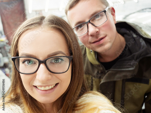 Cute funny blond-haired guy and girl with glasses in the garage