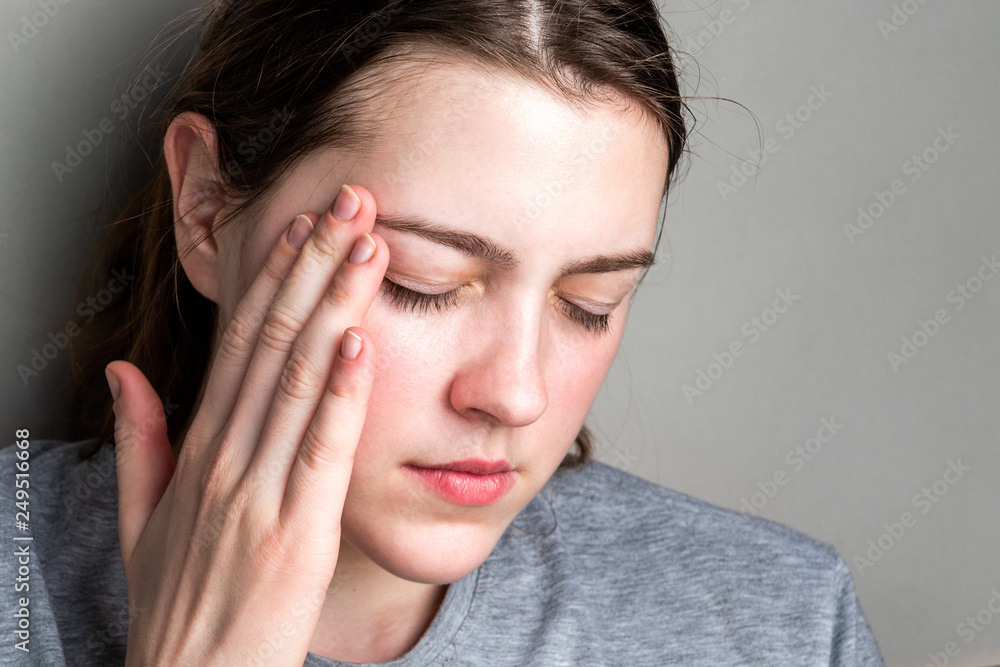 Headache in the temples. Sick girl suffering from head migraine, feeling pressure and stress. Headache in the temples. Sick girl suffering from head migraine, feeling pressure and stress.