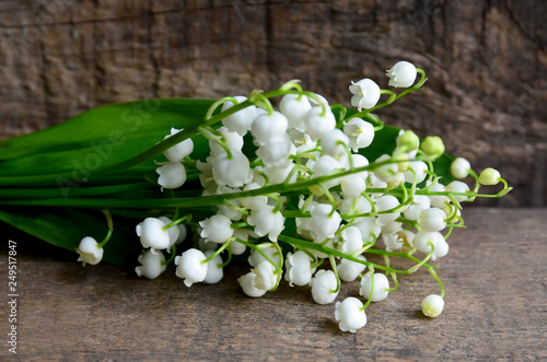 Bouquet of lilies of the valley on old wooden background.Lily of the valley spring flowers.Concept for Mother´s day or Birthday greeting card with copy space.Selective focus.