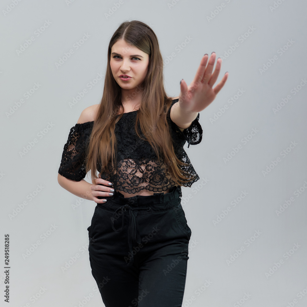 Concept portrait of a pretty beautiful brunette girl talking on a gray background in the studio standing Concept portrait of a pretty beautiful brunette girl talking on a gray background in the studio standing