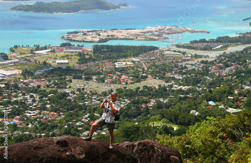 man photographing a landscape standing on the edge of the abyss