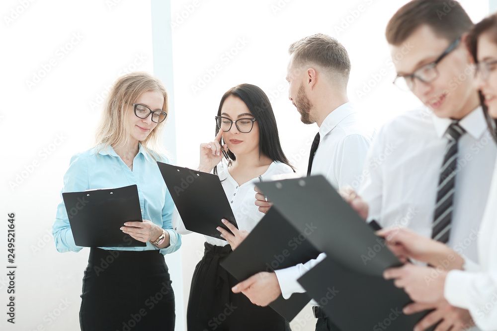 close up.employees with clipboard standing in the office close up.employees with clipboard standing in the office