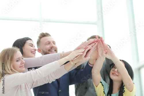 smiling business team joining their hands together.
