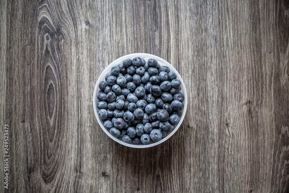 Ripe tasty blueberries and berries on a wooden table in a bowl Ripe tasty blueberries and berries on a wooden table in a bowl