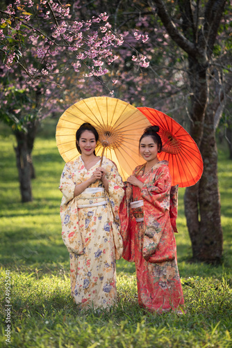 Asian woman wearing traditional japanese kimono with sakura