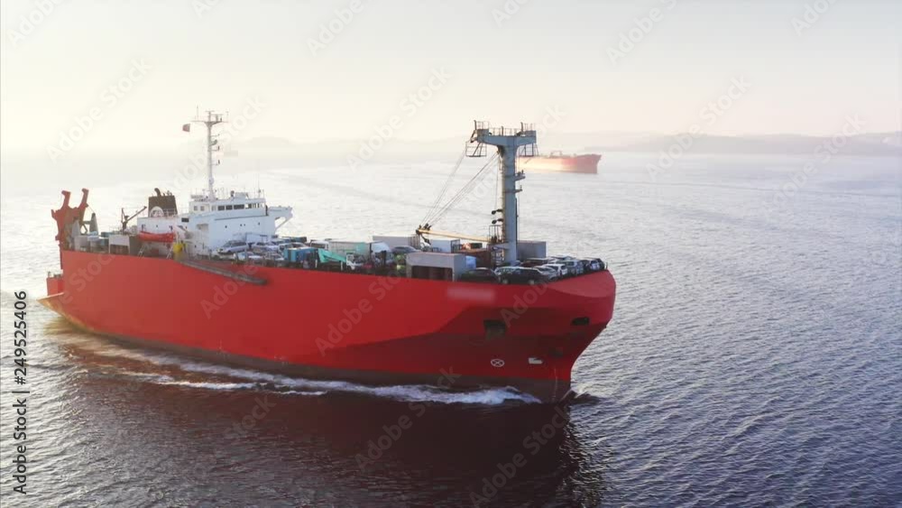 Beautiful aerial view of big red ship with japanese cars on board. The vessel is floating along the Eastern Bosphorus strait to Vladivostok. Sunrise. Russia Beautiful aerial view of big red ship with japanese cars on board. The vessel is floating along the Eastern Bosphorus strait to Vladivostok. Sunrise. Russia
