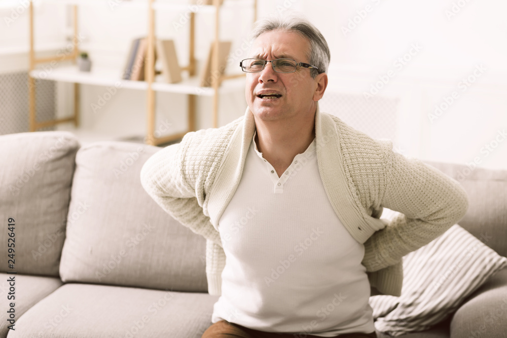 Unhappy senior man suffering from back pain