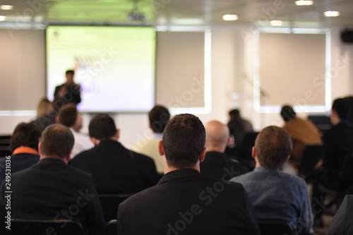 A businessman watches a presentation at an event
