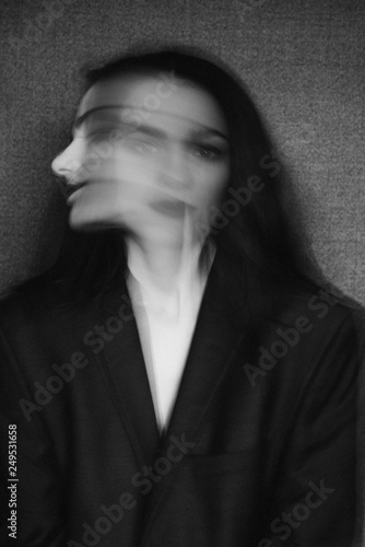 crazy portrait of girl with mental disorders and split personality. Black and white with added grain and motion blur