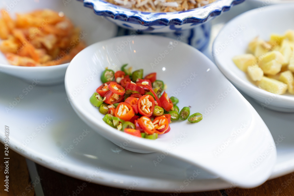 close up sliced red and green chilli on white spoon for miang kum ingredient close up sliced red and green chilli on white spoon for miang kum ingredient