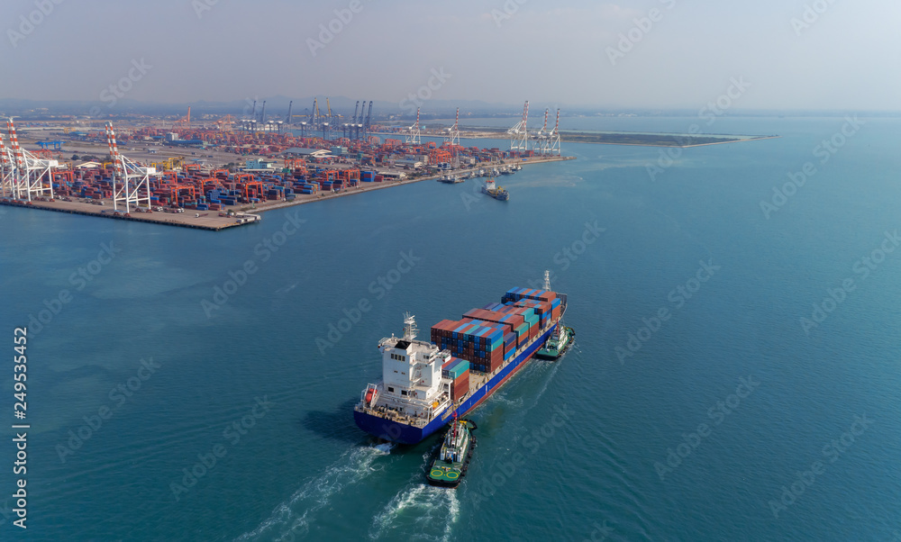 Aerial view container ship going to crane bridge for unload container to warehouse at seaport. Logistics business, import export, shipping or transportation.