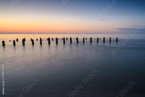 Stakes on the Baltic sea at sunset time, Karwia village, Poland © vivoo