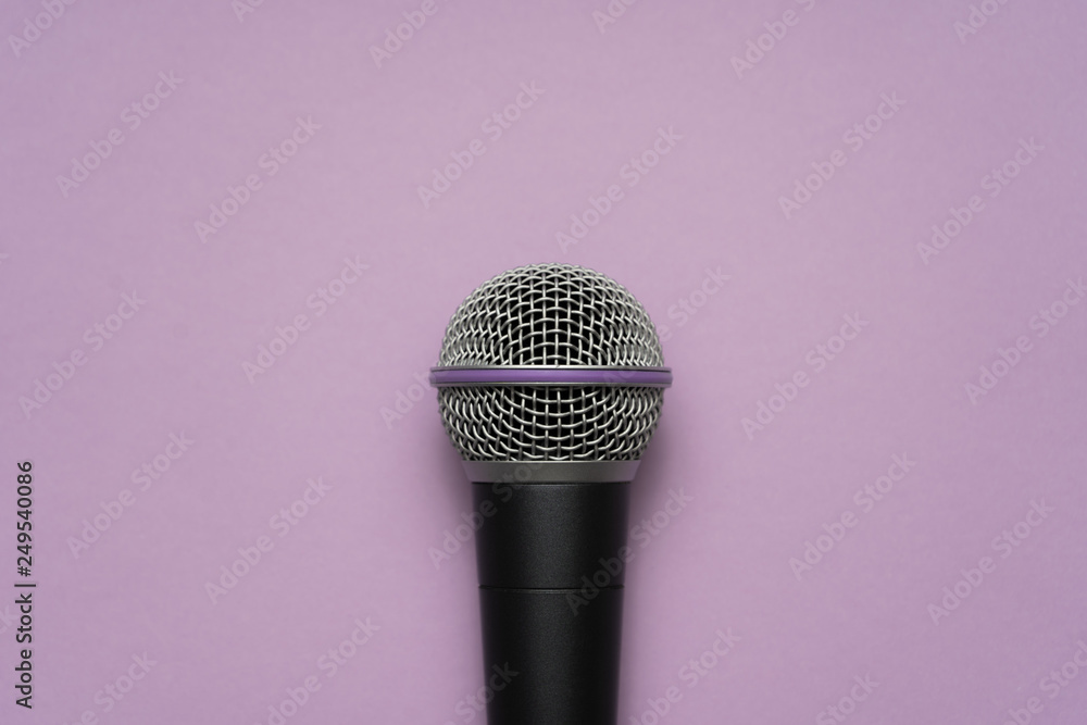 Close-up of a vocal microphone in the center of purple background
