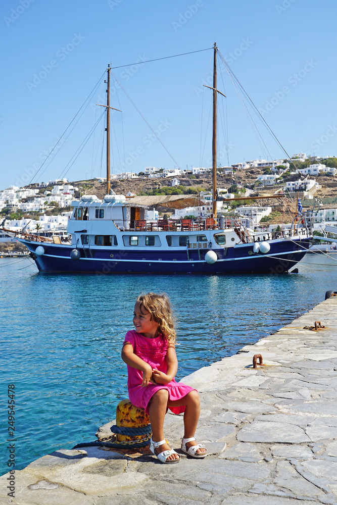 Φωτογραφία Small european tourist plays happy in the small town of Chora in Mykonos