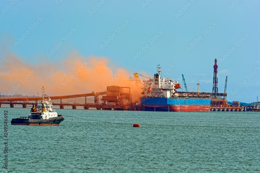 Loading bulk carrier ship with bauxite aluminum ore at Kamsar port, Guinea.