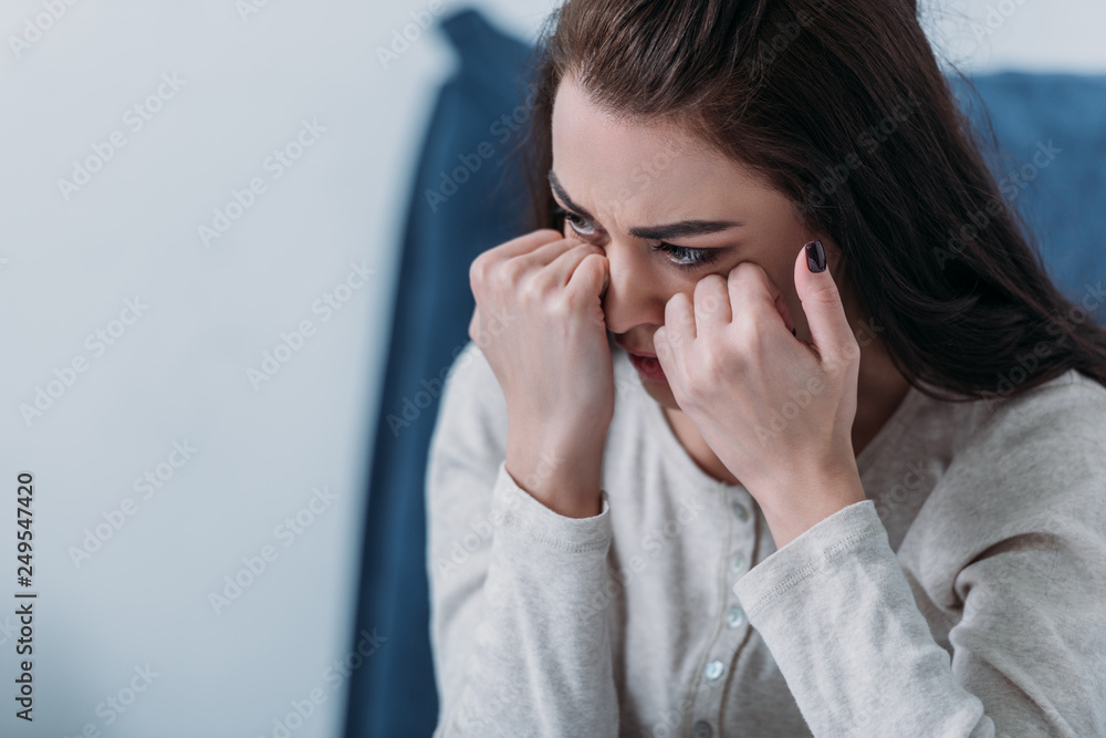 selective focus of depressed woman crying and wiping tears with copy space selective focus of depressed woman crying and wiping tears with copy space