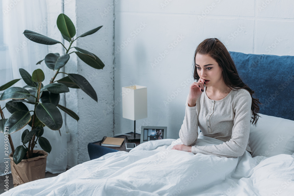 beautiful depressed woman lying in bed and biting finger Stock Photo ...
