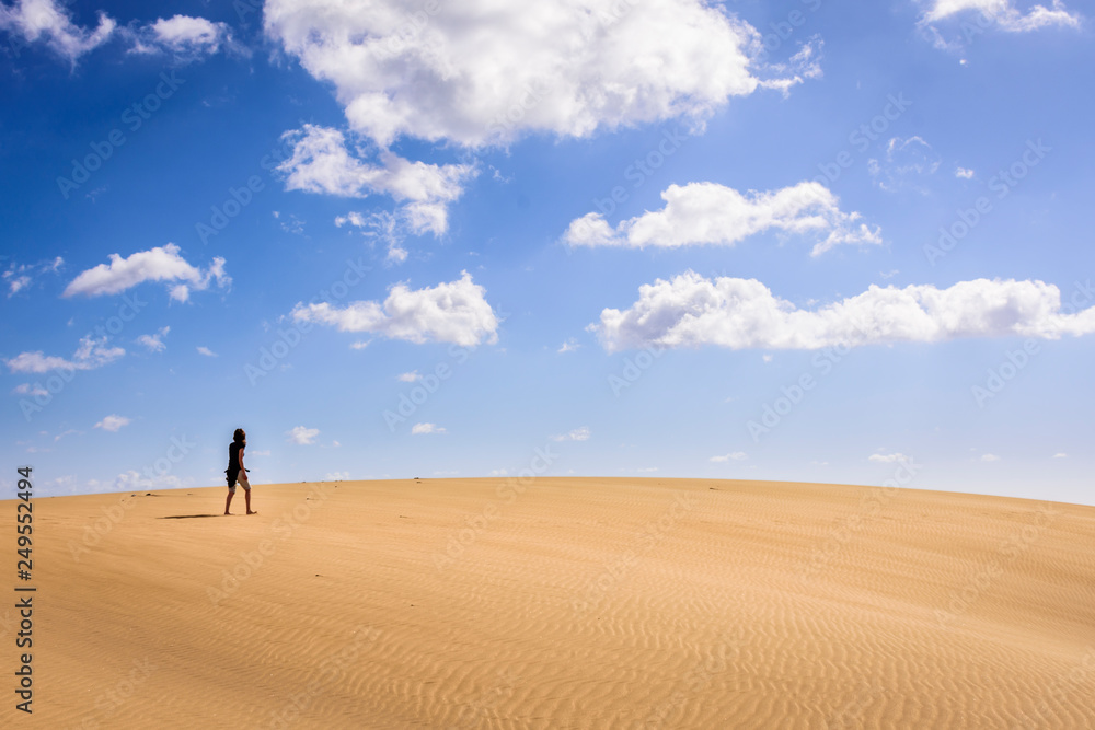 woman walking on dunes in maspalomas, spain woman walking on dunes in maspalomas, spain