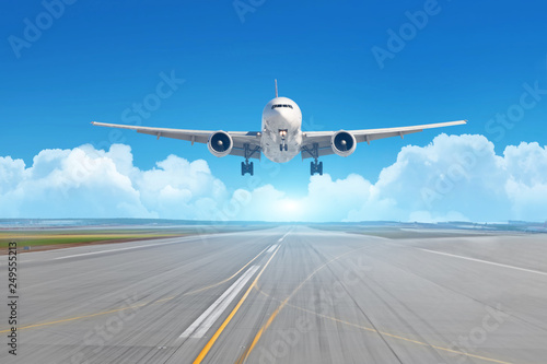 Airplane landing on the runway on a sunny day, in the background picturesque clouds