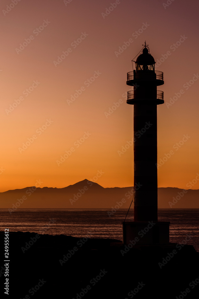 Silhouette Lighthouse By Sea Against Clear Sky During Sunset