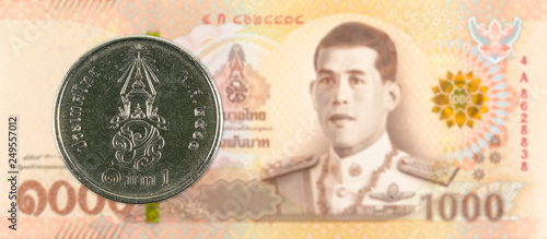 1 new thai baht coin against 1000 new thai baht banknote