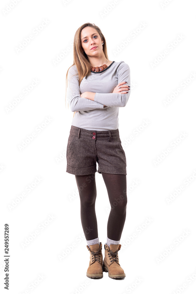 Serious young cute woman in second hand hipster style clothes looking at camera with crossed arms. Full body isolated on white background. Serious young cute woman in second hand hipster style clothes looking at camera with crossed arms. Full body isolated on white background.