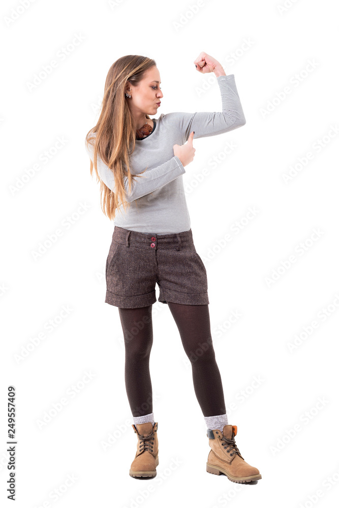 Girl power concept. Slim pretty young woman flexing slim arm bicep muscle.  Full body isolated on white background. Stock Photo