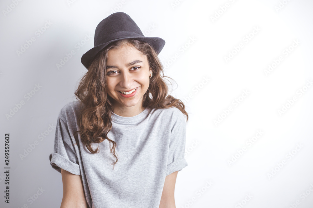 Smiling brunette in a black hat. Portrait of a happy young woman on a white background. Smiling brunette in a black hat. Portrait of a happy young woman on a white background.