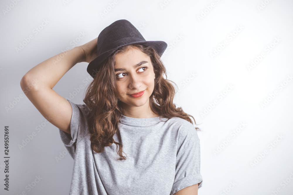 Smiling brunette in a black hat. Portrait of a happy young woman on a white background. Smiling brunette in a black hat. Portrait of a happy young woman on a white background.