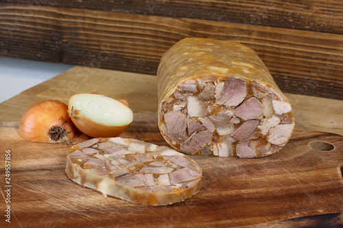 Home made head cheese with onion on wooden background