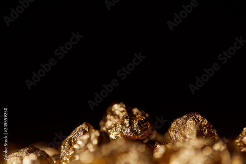 selective focus of gold stones isolated on black