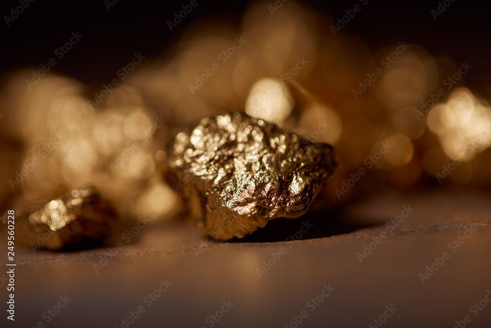 selective focus of golden stones on marble and dark blurred background