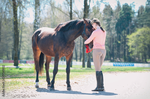 Young teenage girl owner hugging her favorite horse