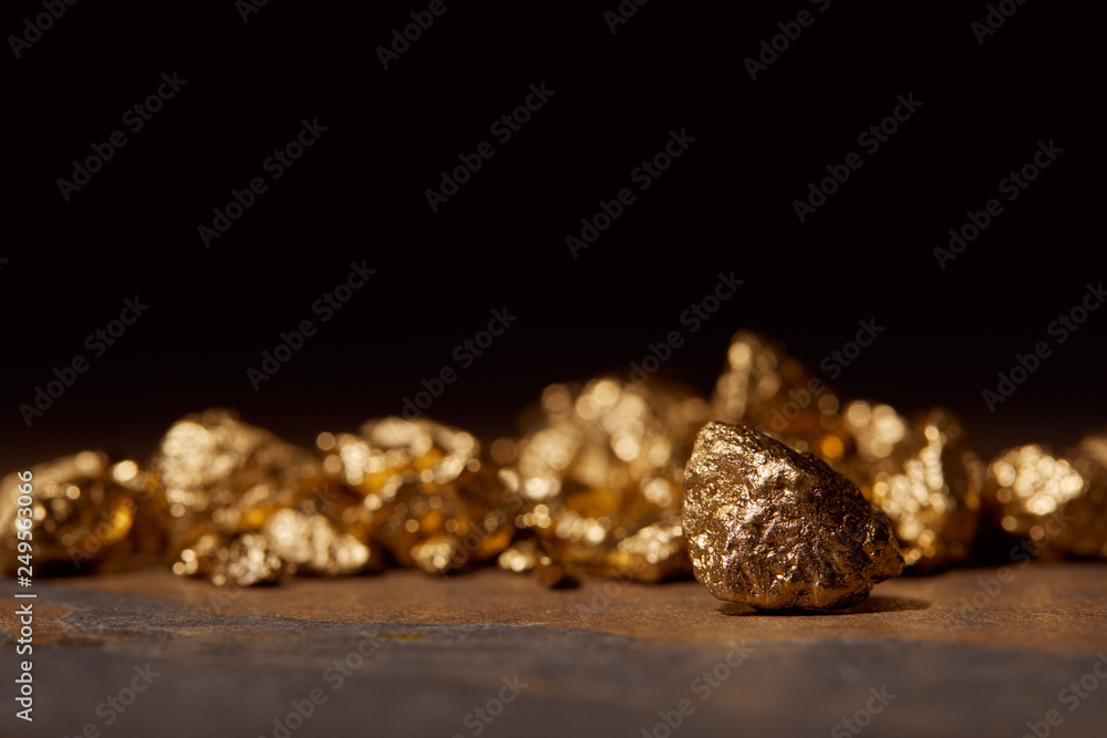 selective focus of golden stones on dark marble isolated on black selective focus of golden stones on dark marble isolated on black