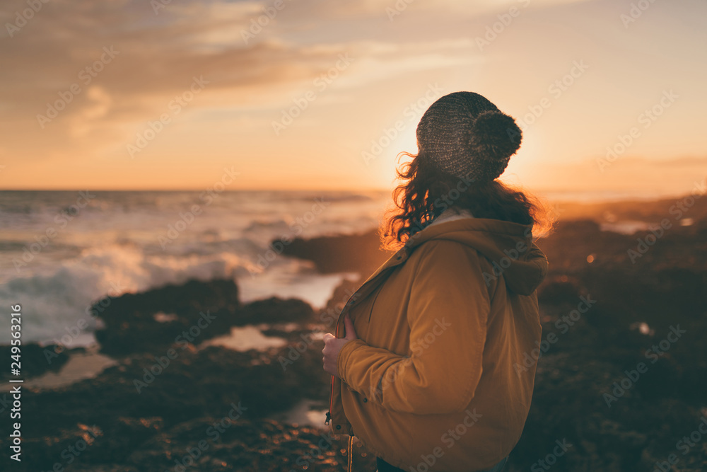 woman in autumn by the sea at sunset