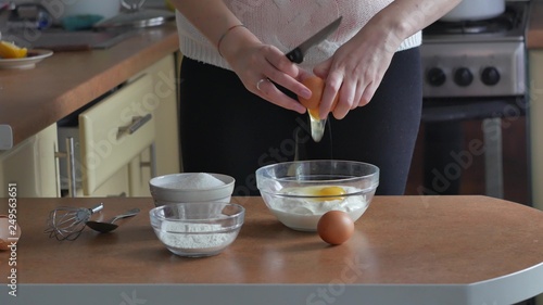 Close up of hands cracking an egg on a bowl and pouring it in, close up