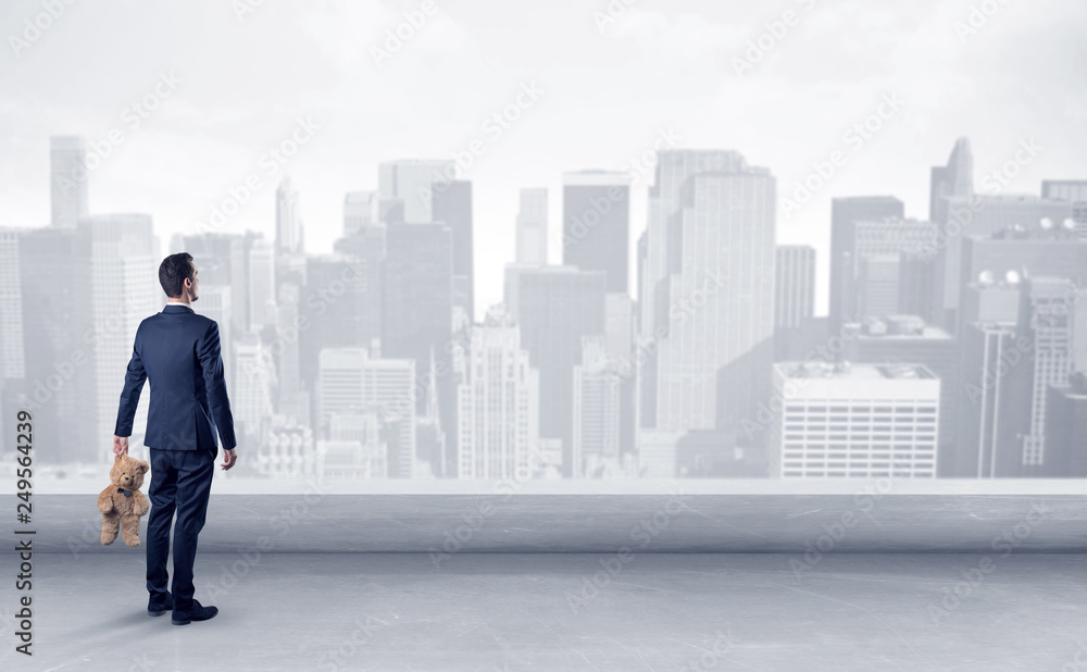 Businessman standing with his back on a roof with objects in his hand
