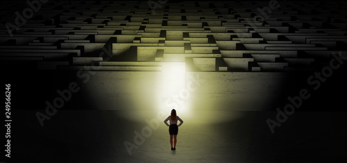 Woman getting ready to enter the dark labyrinth with illuminated door 