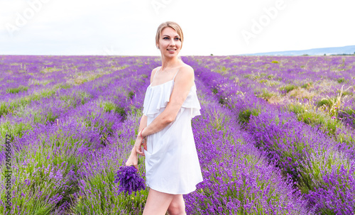 Fototapeta Naklejka Na Ścianę i Meble -  Girl in white dress with bouquet on lavender field