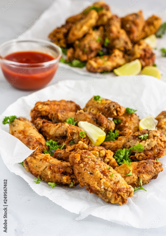 Crispy Baked Chicken Wings with Lemon Wedges and Red Chili Sauce