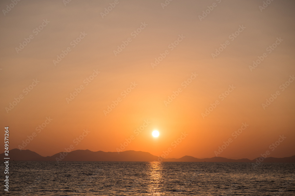 Sunset seascape with coastline on the horizon