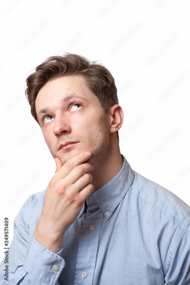 Thinking man isolated on white background. Closeup portrait of a casual young pensive businessman looking up at copyspace.